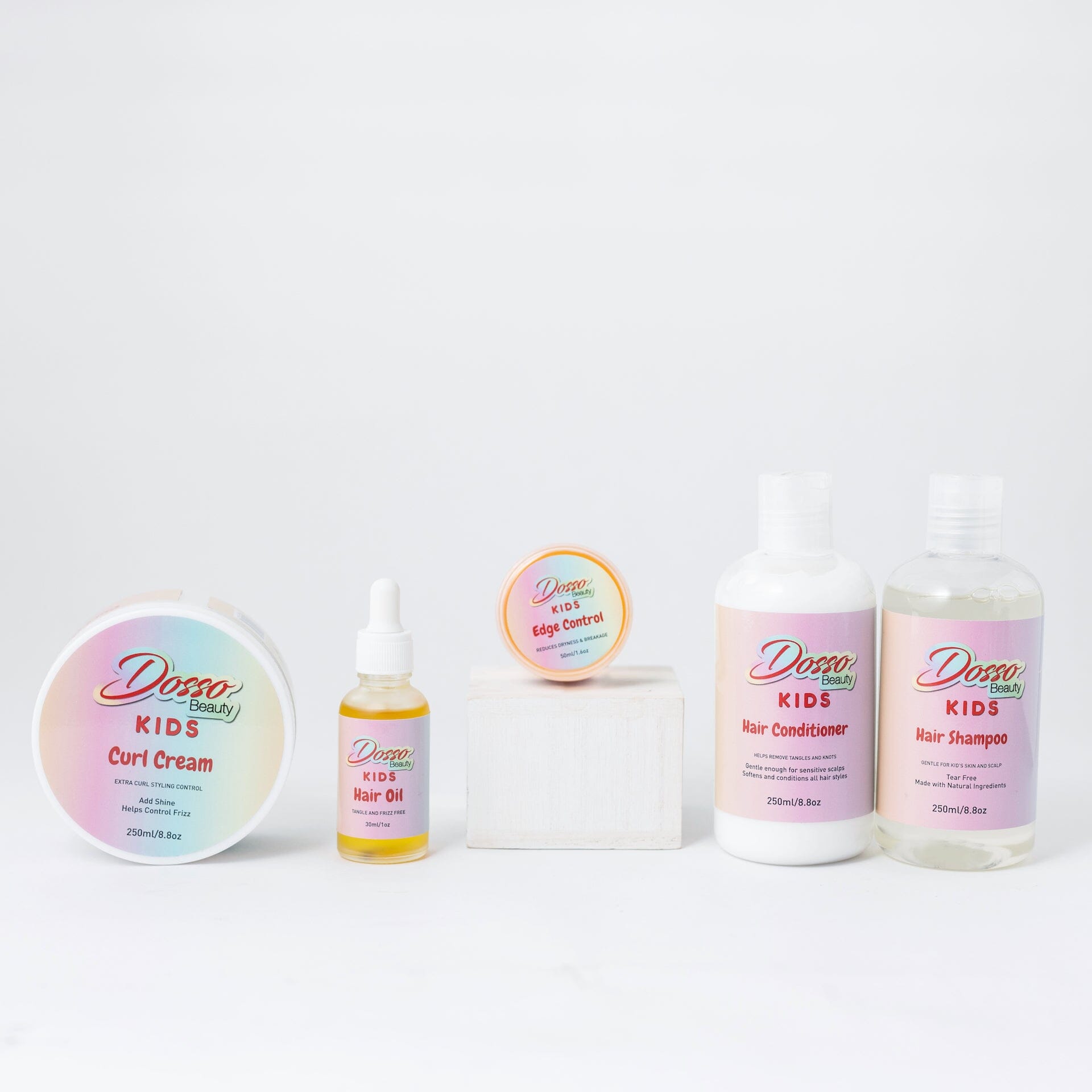 A group of kids hair care products, all branded with rainbow ombré labels, standing on a white field.