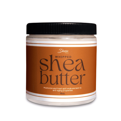 A translucent round jar with a black lid. Jar is full of a white cream and has a label that reads "Whipped Shea Butter."